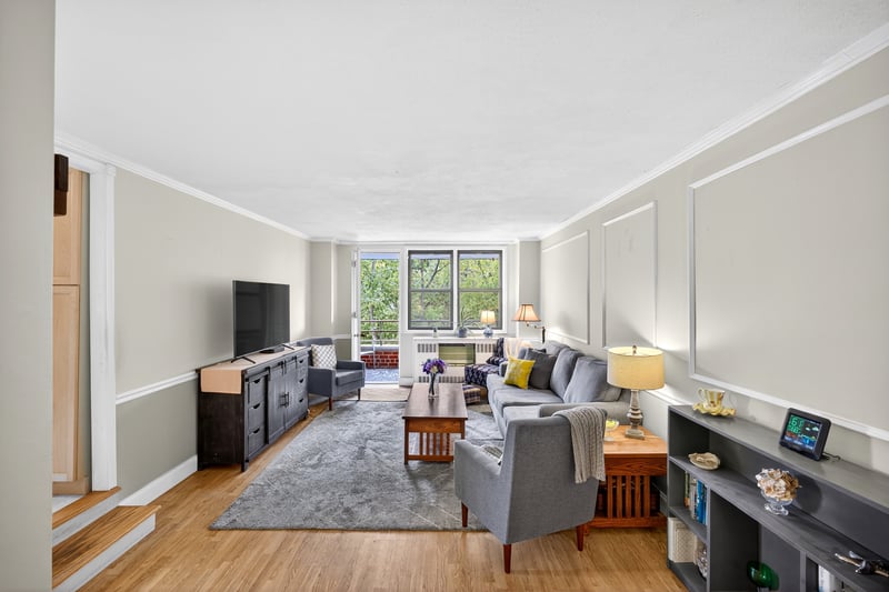 Living room featuring ornamental molding, light wood finished floors, and floor to ceiling windows