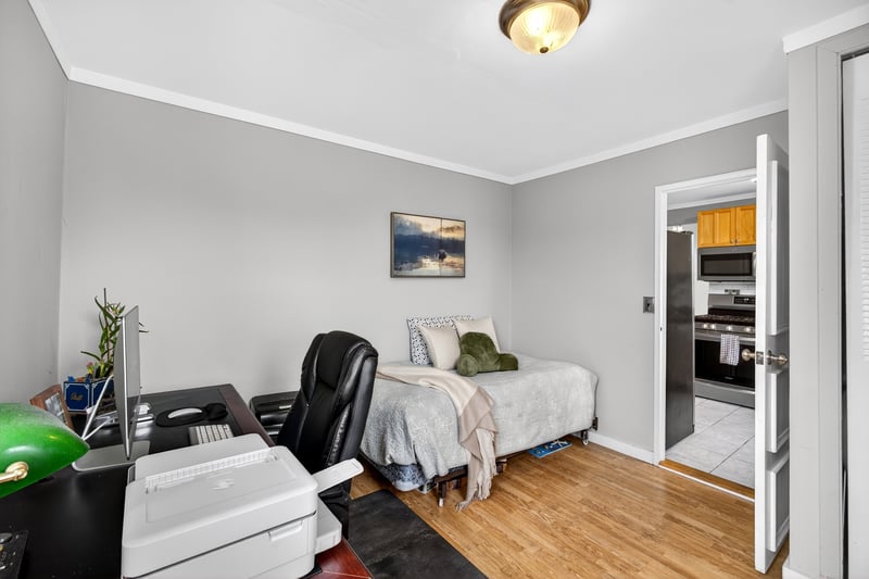 2nd Bedroom featuring ornamental molding, light wood-type flooring, freestanding refrigerator, and a desk