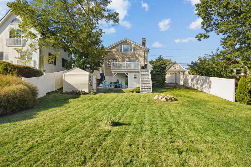 Large yard with grass and storage shed