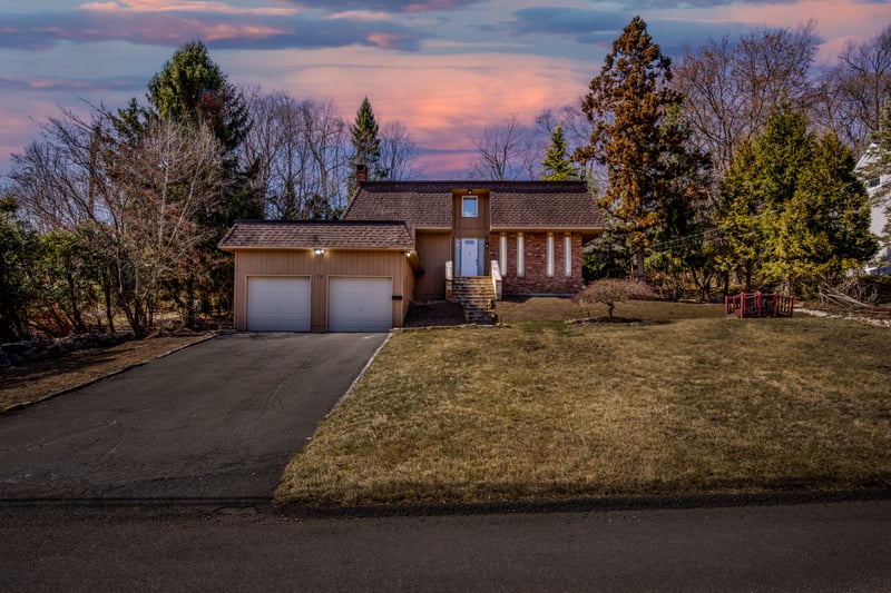 View of front of home featuring roof with shingles, a yard, asphalt driveway, mansard roof, and an attached garage...