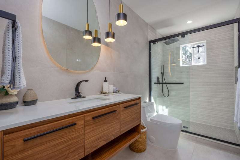 Bathroom with tile walls, vanity, a shower stall, and light tile patterned floors