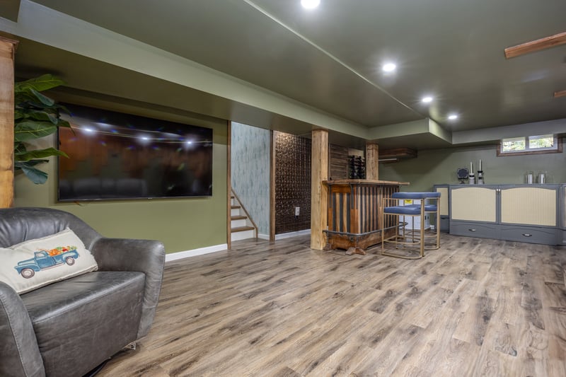 Indoor dry bar with wood finished floors, stairs, and recessed lighting