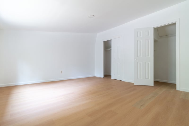 Unfurnished bedroom with light wood-type flooring and two closets