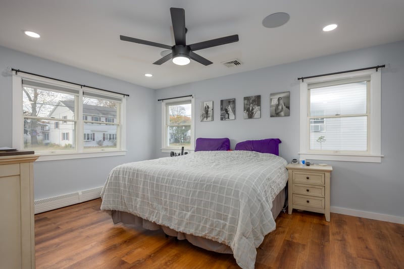 Bedroom with wood finished floors, a baseboard radiator, ceiling fan, and recessed lighting