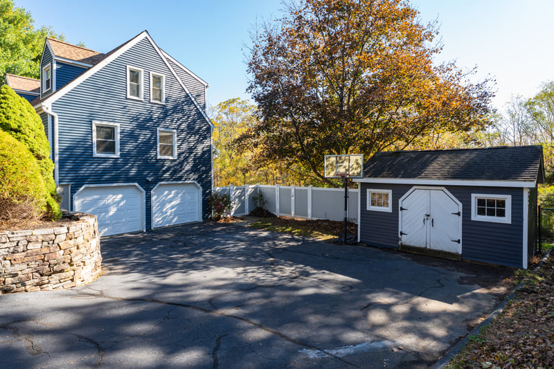 Garage access and shed with a large driveway.