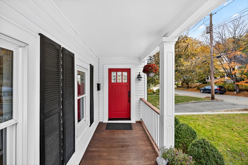 Property entrance featuring covered porch and front yard