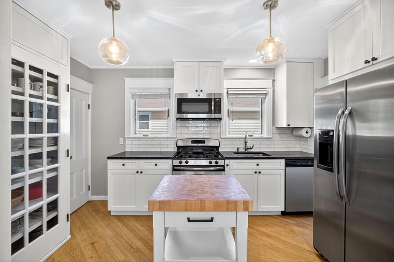 Kitchen featuring appliances with stainless steel finishes, white cabinetry, light wood-style floors