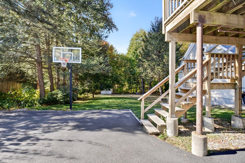 View of driveway, backyard and stairs to the deck
