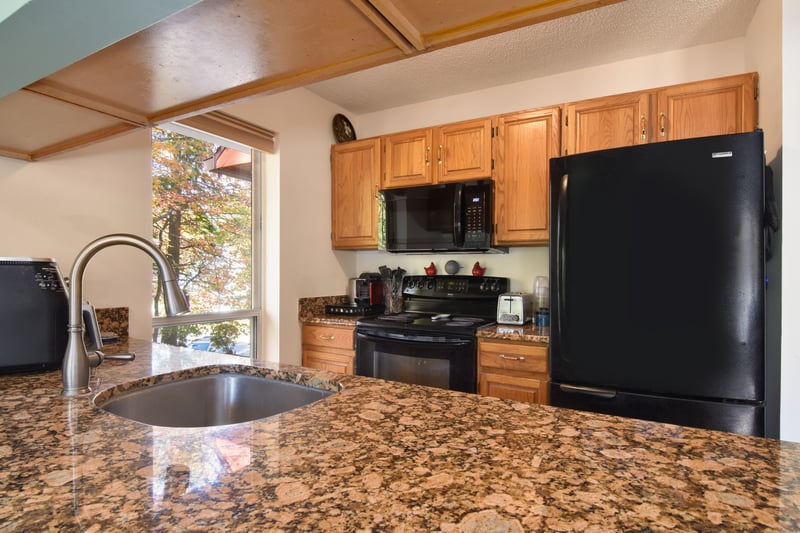 A well-appointed galley kitchen features granite countertops, coordinated appliances, and an integrated dishwasher for easy cleanup.