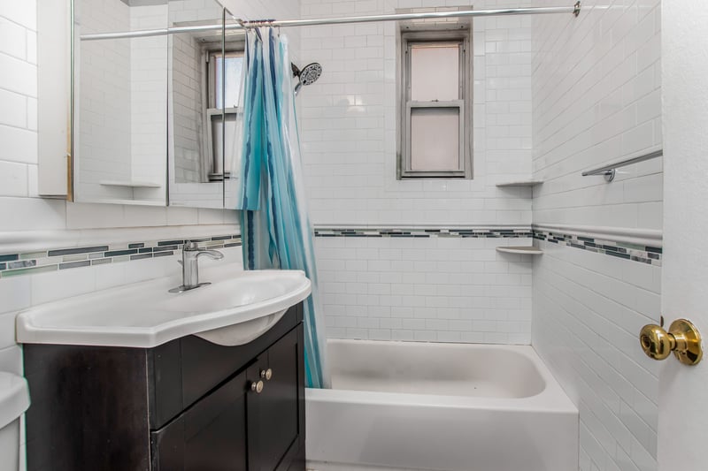 Full bathroom with vanity, shower / bath combo with shower curtain, tile walls, and backsplash