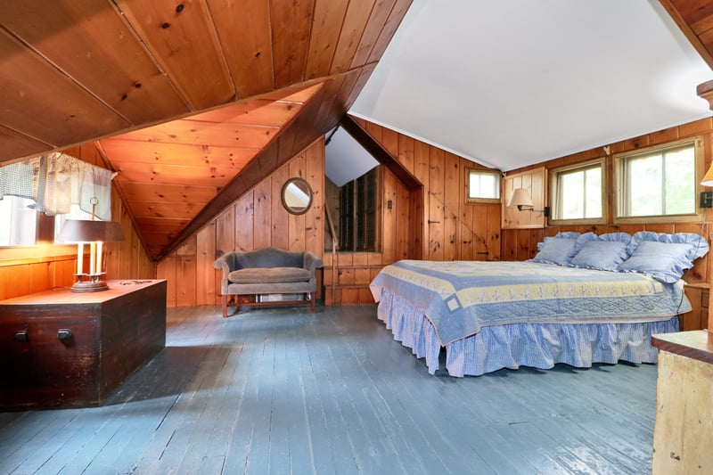 The loft bedroom, with closets up the few stairs, with a walk-in attic beyond.
