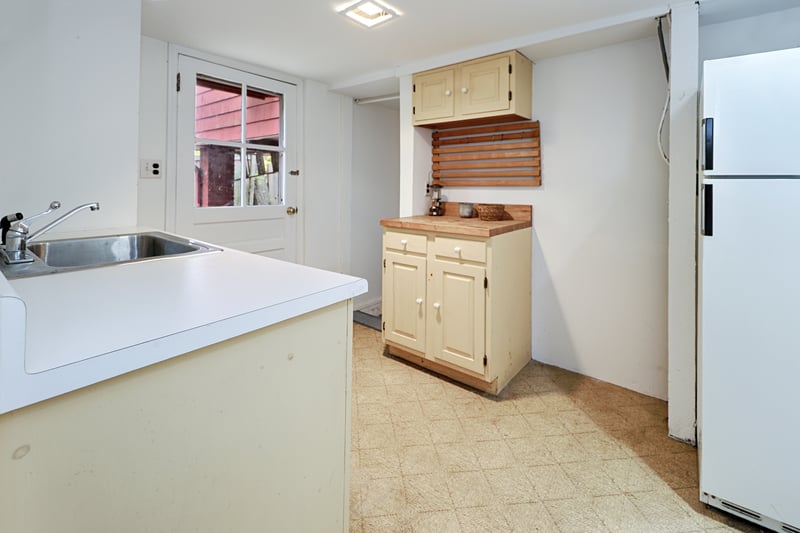 There is a small kitchen area, with a door that leads to the carport area. There is no stove currently.