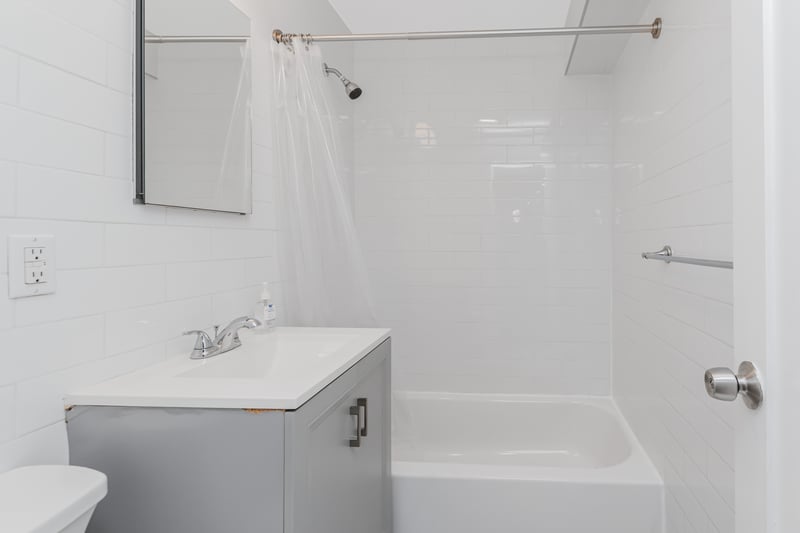 Full bath with vanity, shower / bath combo, and tile walls