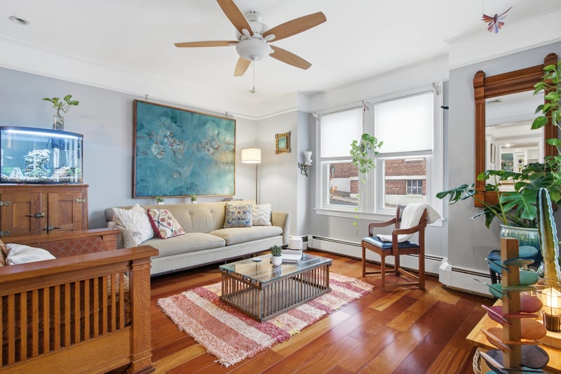 Living room featuring hardwood / wood-style flooring, ceiling fan, and crown molding