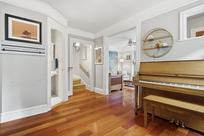 Hallway featuring crown molding, light wood-type flooring, and stairs