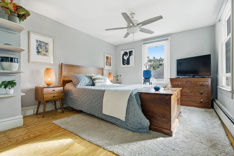 Hall featuring a baseboard heating unit, light wood-style floors, an upstairs landing, and healthy amount of natural light