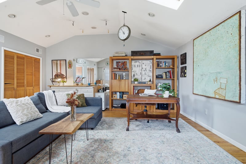 Living room with lofted ceiling, light wood finished floors, a skylight, recessed lighting, and healthy amount of natural light