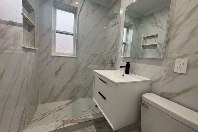 Full bath with marble style tiled floors, vanity, tile walls, a marble finish shower