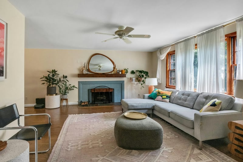Living area featuring wood finished floors, a fireplace, and ceiling fan