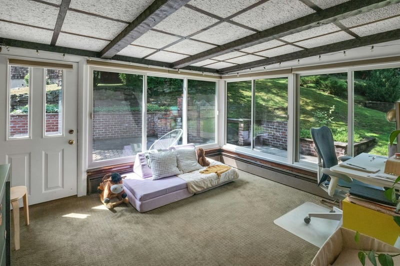 Sunroom with carpet flooring and baseboard heating