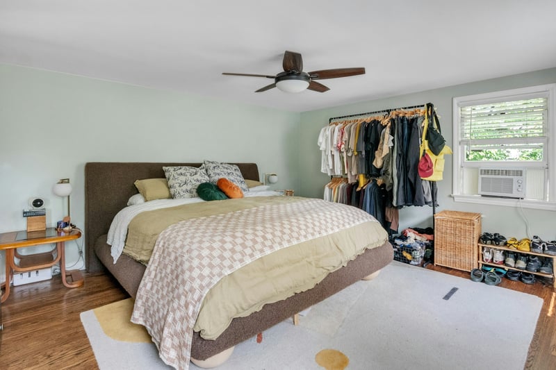 Bedroom featuring wood finished floors, ceiling fan, and cooling unit