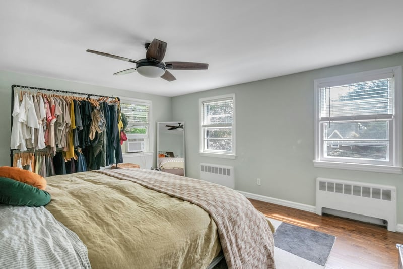 Bedroom with radiator, wood finished floors, and a ceiling fan
