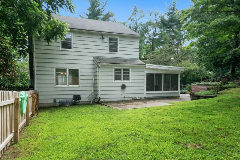 Rear view of property with a sunroom, roof with shingles, a patio, and a fenced backyard