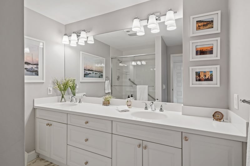 Primary bathroom with large shower, Corian topped vanity with double sinks and beautiful polished marble floor.