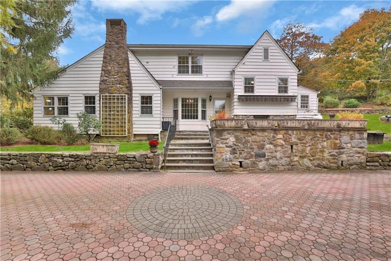 Rear view of property with a patio, a chimney, and stairs