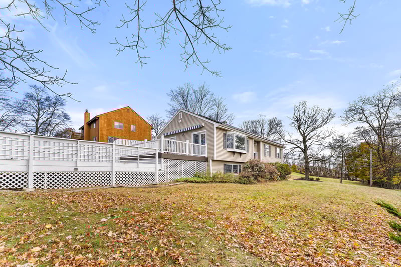 Rear view of property featuring a deck and a yard