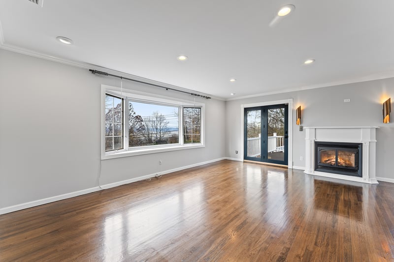 Unfurnished living room with crown molding, a glass covered fireplace, recessed lighting, dark wood-style floors, and french doors