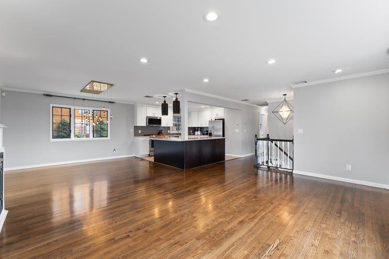 Kitchen with open floor plan, ornamental molding, a chandelier, white cabinets, and pendant lighting