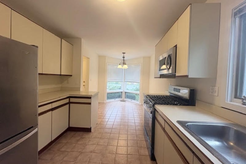 Kitchen featuring stainless steel appliances, light countertops, pendant lighting
