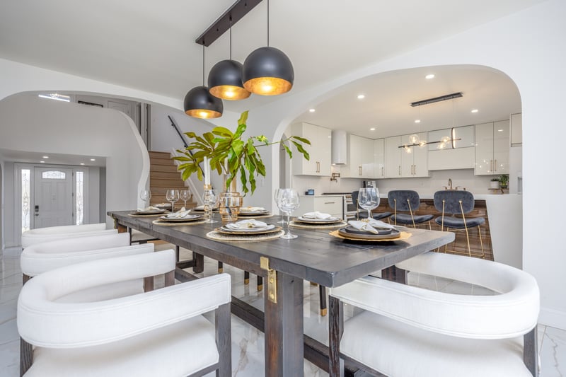 Dining area with recessed lighting, light marble finish flooring, arched walkways, and stairway