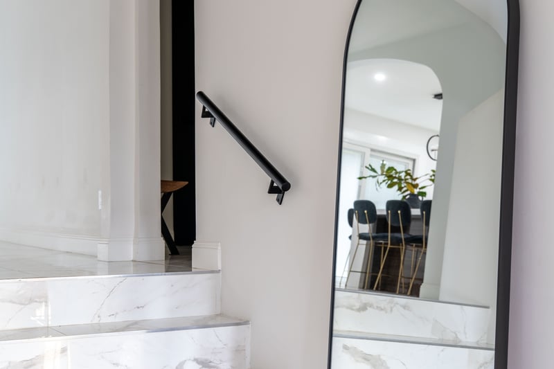 Staircase featuring arched walkways and marble tiled flooring