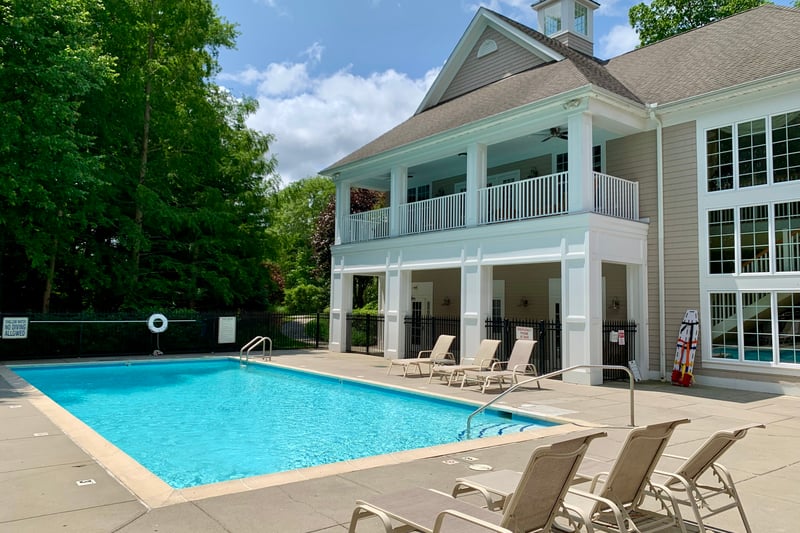 Clubhouse with heated pool, multi sports court, fitness center and gathering room with fireplace, bar & kitchen.