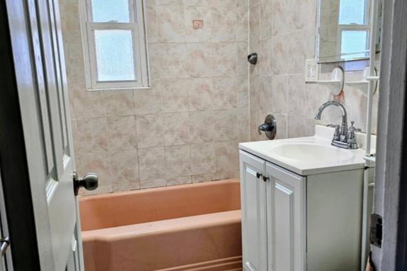 Full bath with shower / washtub combination, vanity, and tile walls