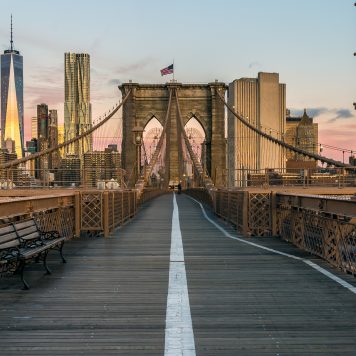 The Famous Brooklyn Bridge at Sunrise, New York City, USA. The sun is rising over Brooklyn on this beautiful day of Autumn