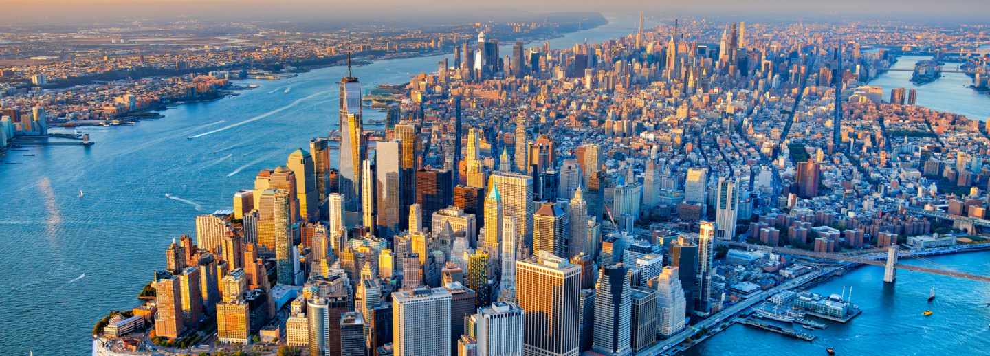 The skyline of Lower Manhattan's Financial District as well as the entire island of Manhattan, New York City, shot wide angle via helicopter from an altitude of about 1500 feet over New York Harbor.