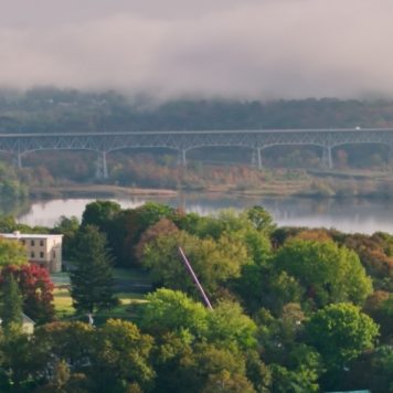 Aerial shot of Catskill, New York on a sunny day with rolling fog over the mountains.